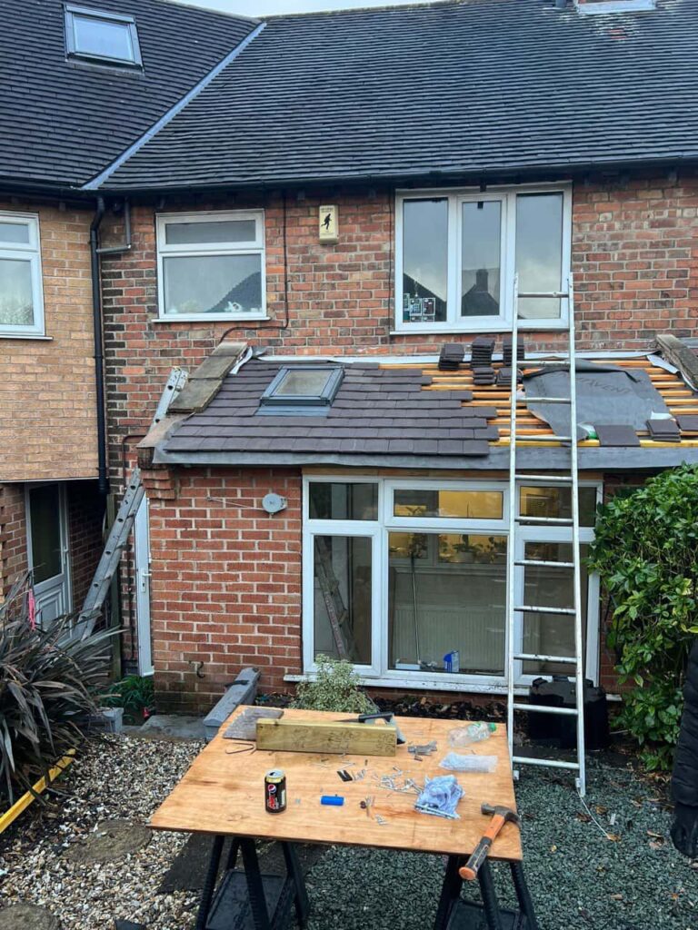 This is a photo of a roof extension that is having new roof tiles installed. This is a photo taken from the roof ridge looking down a tiled pitched roof on to a flat roof. Works carried out by Horndean Roofing Repairs