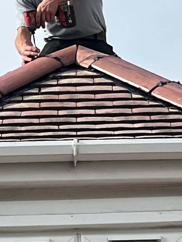 This is a photo of one of the operatives of Horndean Roofing Repairs installing new ridge tiles